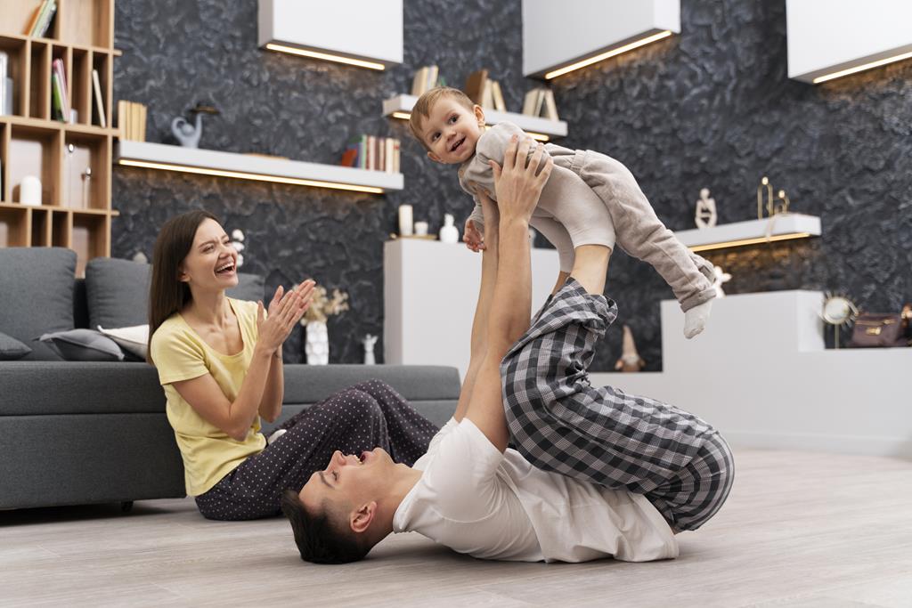 Qualidade de vida: Conquiste esse sonho: pai, mãe e filho pequeno curtindo um momento em família na sala de seu apartamento